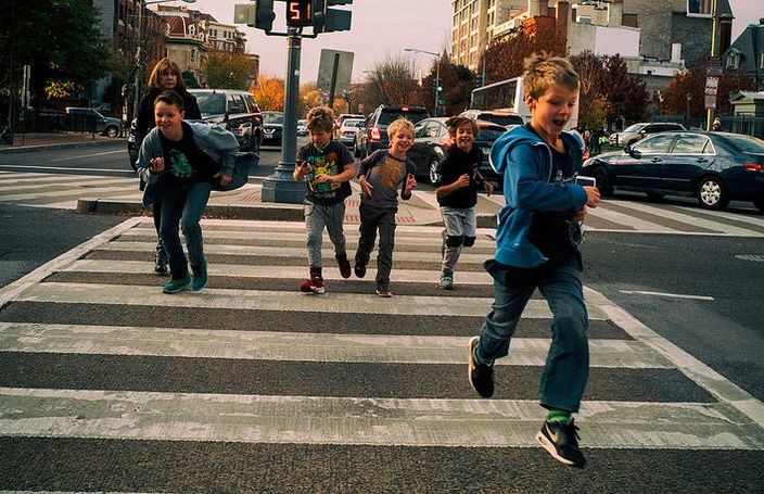 A group of joyful children are crossing the street, but many of them still need special education.